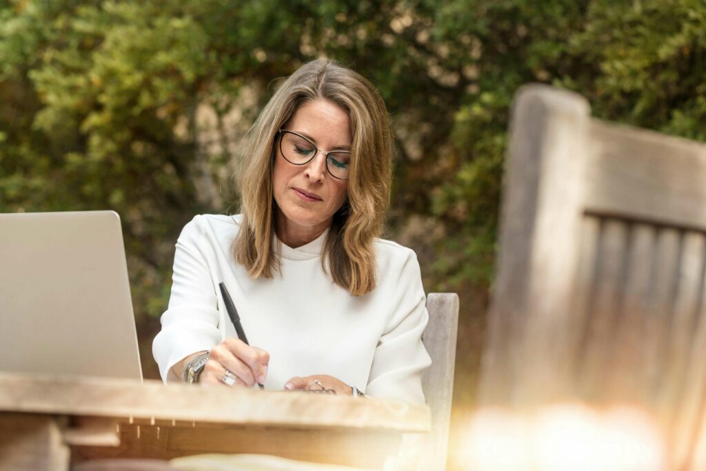 Femme corrigeant un manuscrit en extérieur.