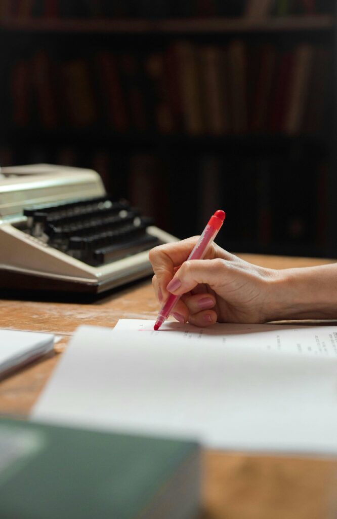 Correctrice tenant un feutre rouge, en train de corriger un manuscrit.